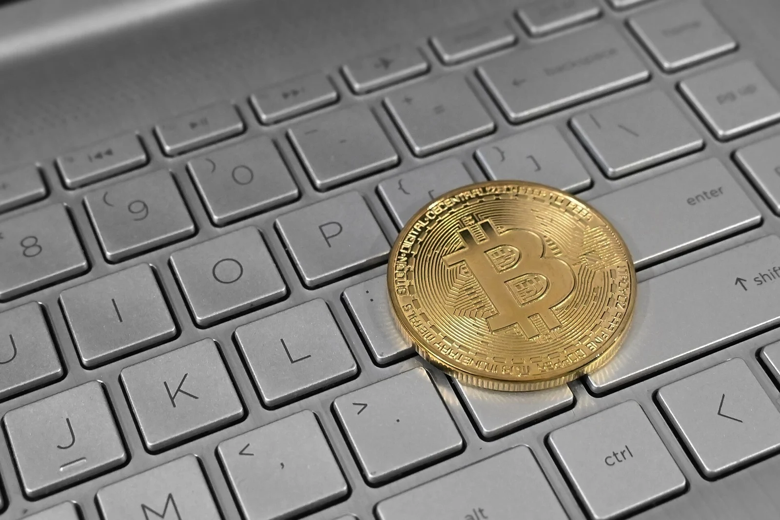 Un token físico de bitcoin sobre un teclado; imagen ilustrativa, no el colateral de PowerCompute.