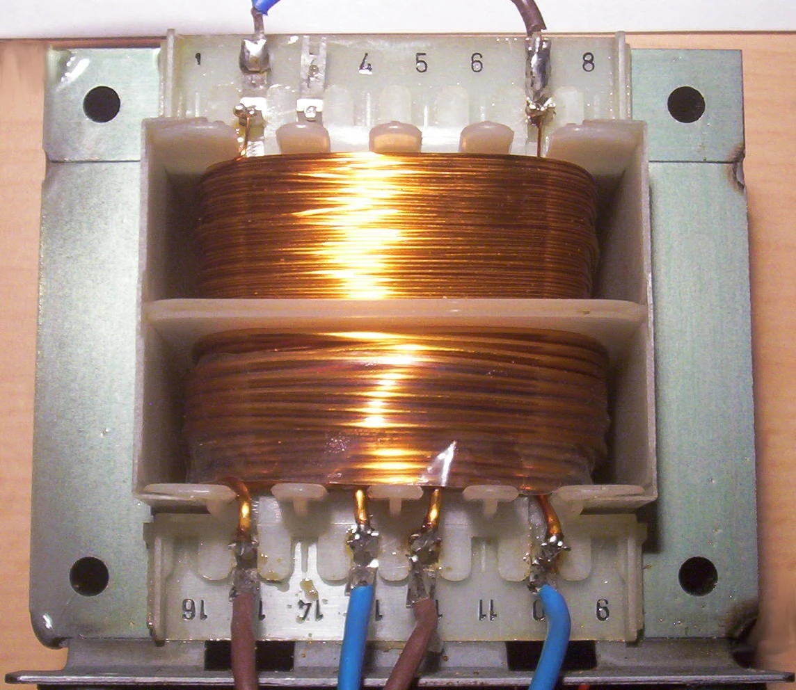 Interior of a small 100 VA transformer photographed in 2007; illustrative construction, not the announced pressboard line.