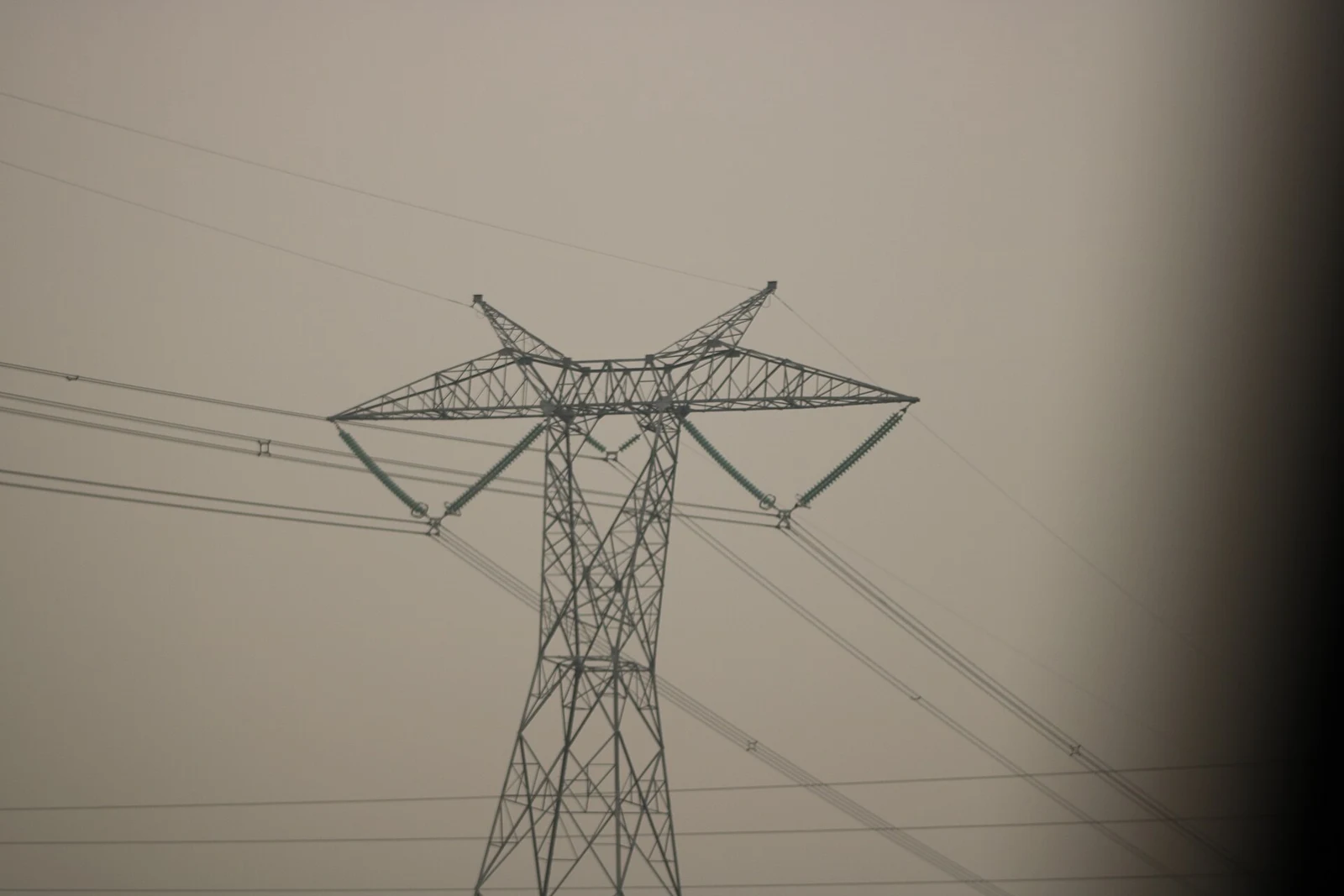 Western Alberta Transmission Line tower photographed from Alberta Highway 2 in 2018. The grid carries electricity; a wholesale market price and a customer’s complete bill remain different measures.
