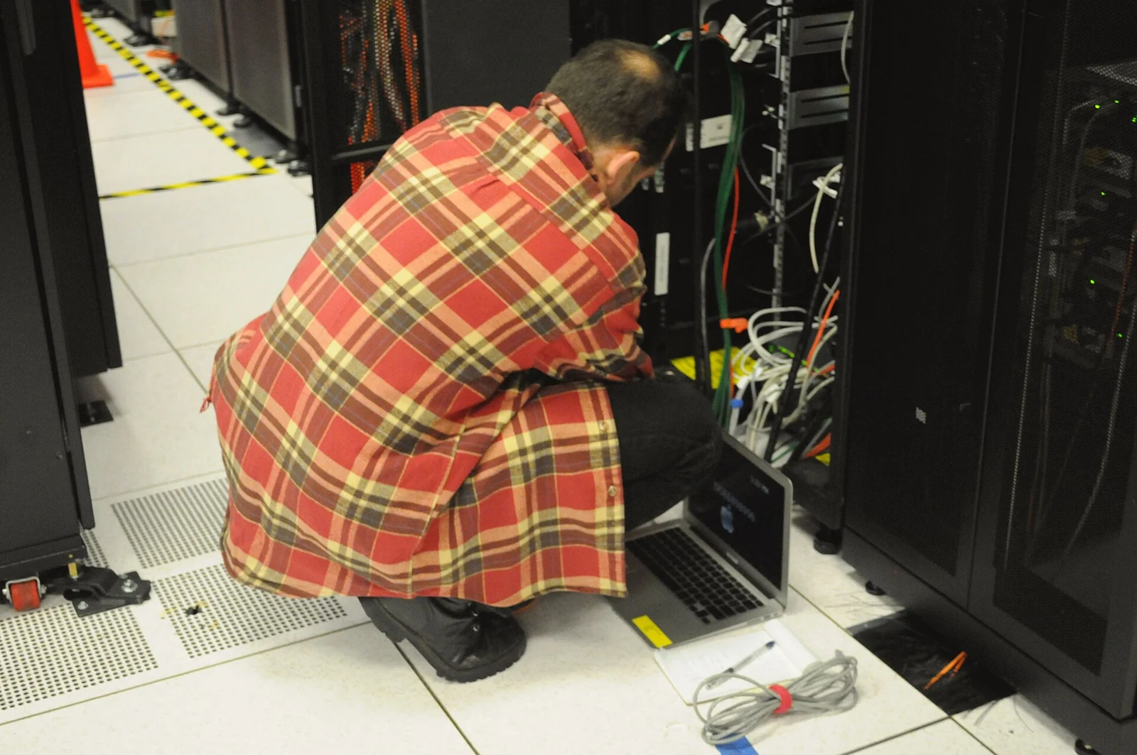 Technician at NERSC server racks; archive computing illustration, not a Bitdeer data center